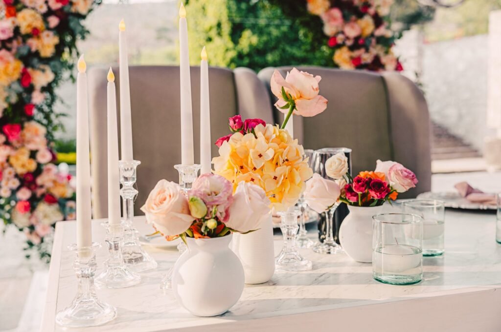 Arreglo floral con velas y cristalería sobre mesa