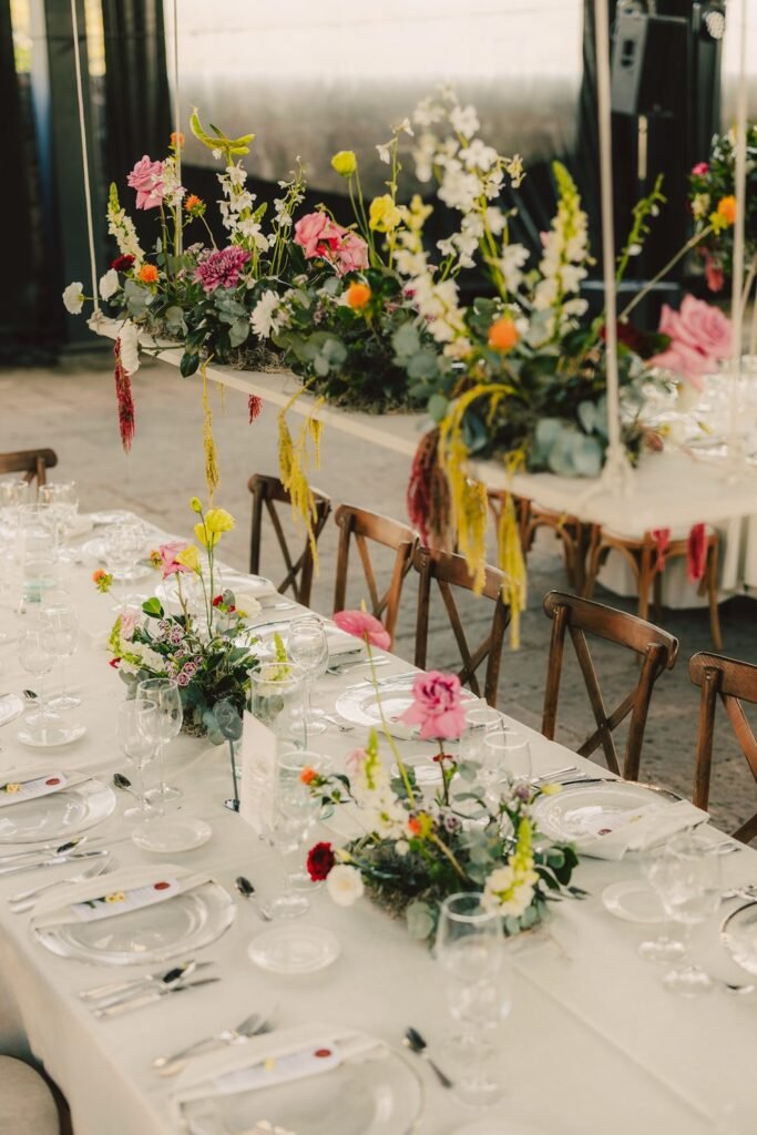 Mesa larga con arreglos florales de colores